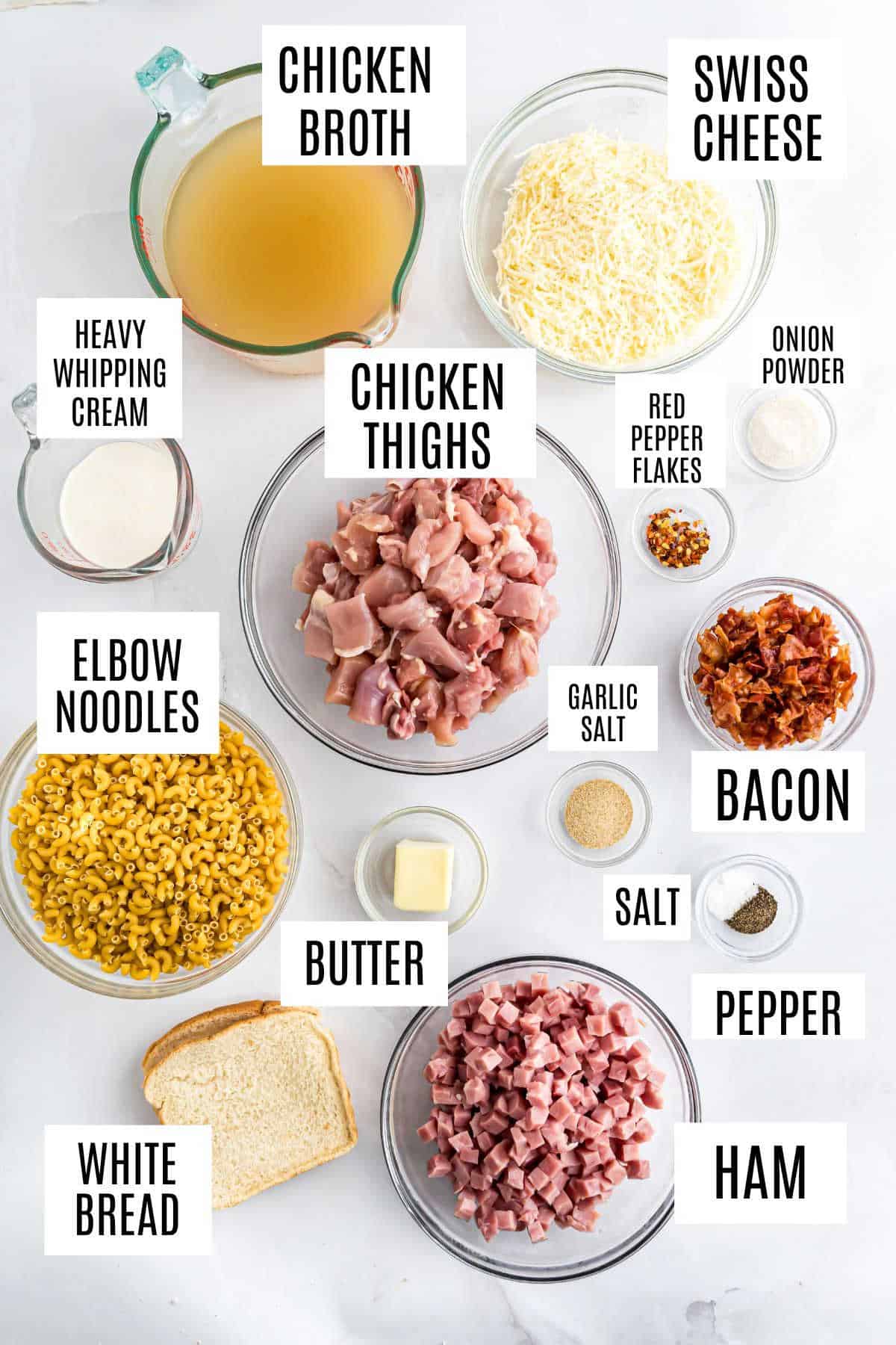 Ingredients for an instant pot chicken cordon bleu casserole, labeled: chicken, ham, bacon, noodles, cheese, broth, cream, spices, butter, and bread.