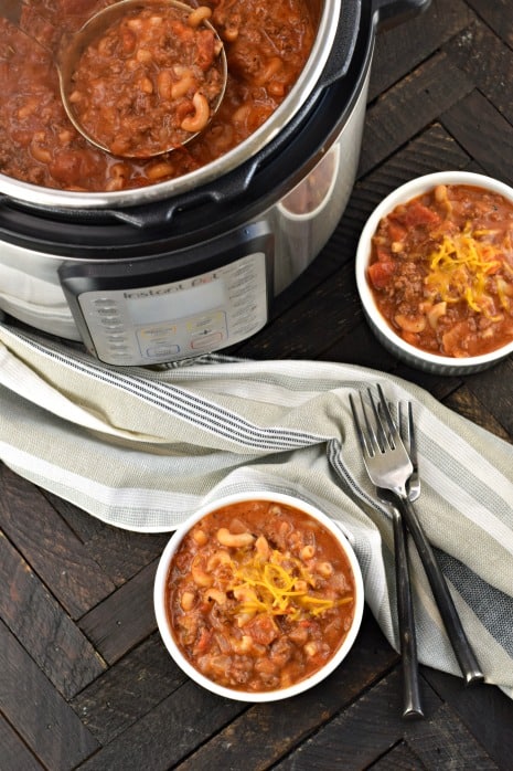 Two bowls of american goulash with Instant Pot filled with more beefy chili mac.