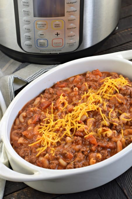 Oval white baking dish filled with beefy chili mac with Instant Pot in background.