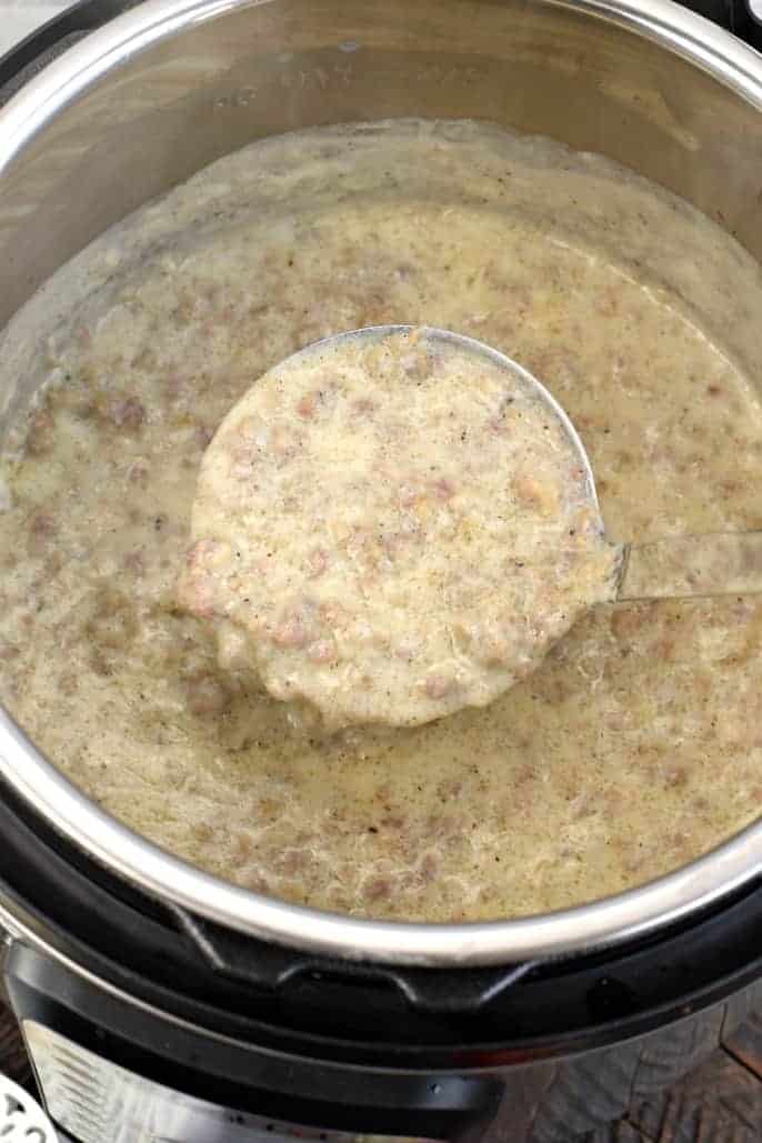 Instant Pot filled with sausage gravy. Big silver ladle lifter up!
