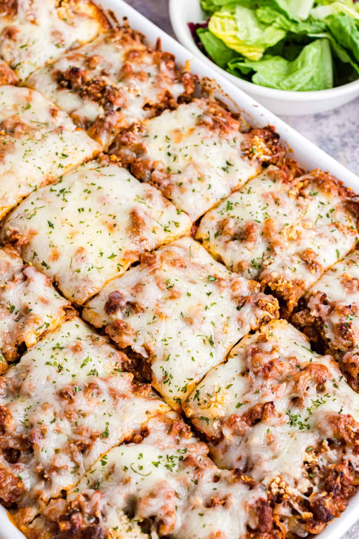 Million Dollar Spaghetti casserole in 13x9 baking dish cut into squares.