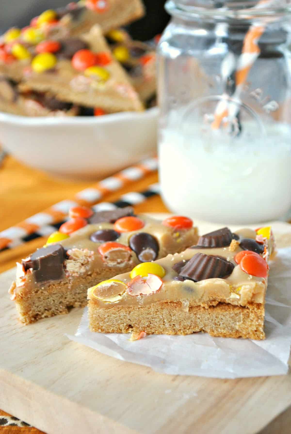Peanut butter cookie bar cut into a triangle shape and topped with reeses pieces.