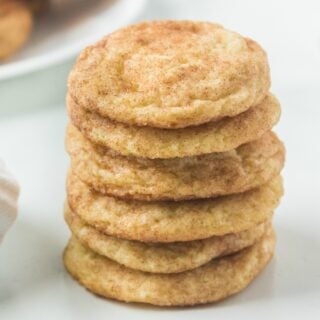 Stack of six snickerdoodle cookies on white table.
