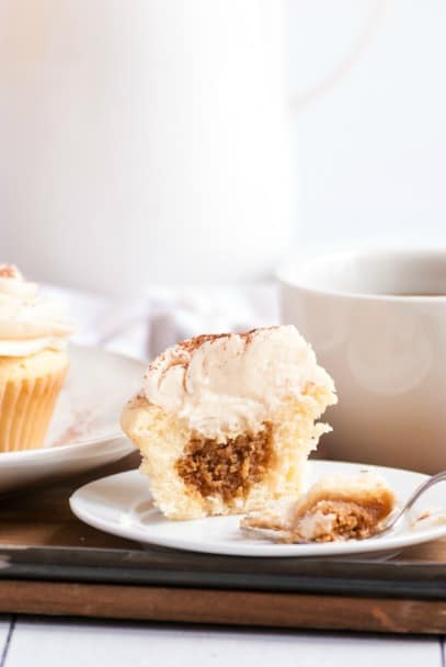 Vanilla cupcake with espresso filling and frosting broken in half to see the filling.