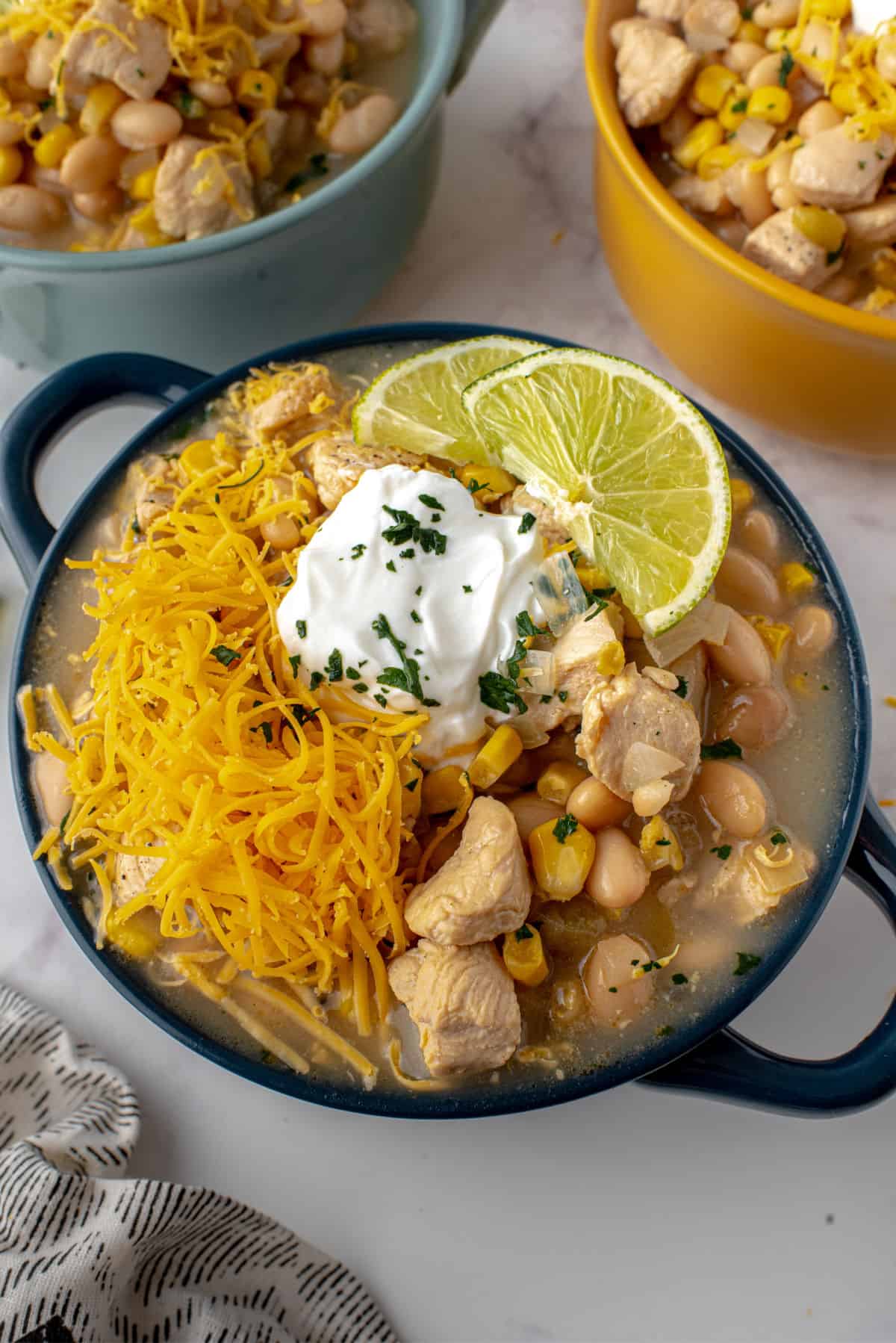 White chicken chili with toppings in a bowl.