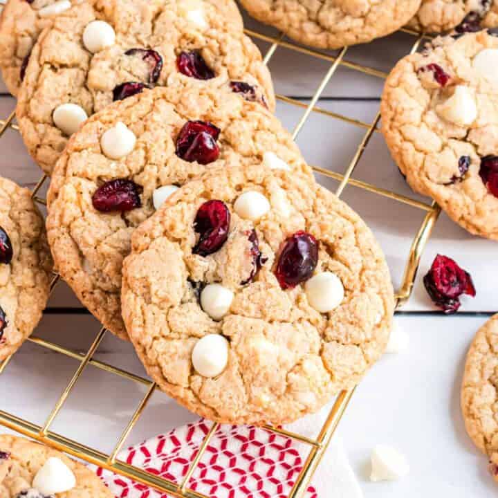 Stack of white chocolate cranberry cookies on wire cooling rack.