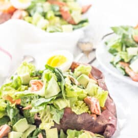 Homemade caesar salad stuffed into a baked sweet potato and topped with salmon and hard boiled egg.