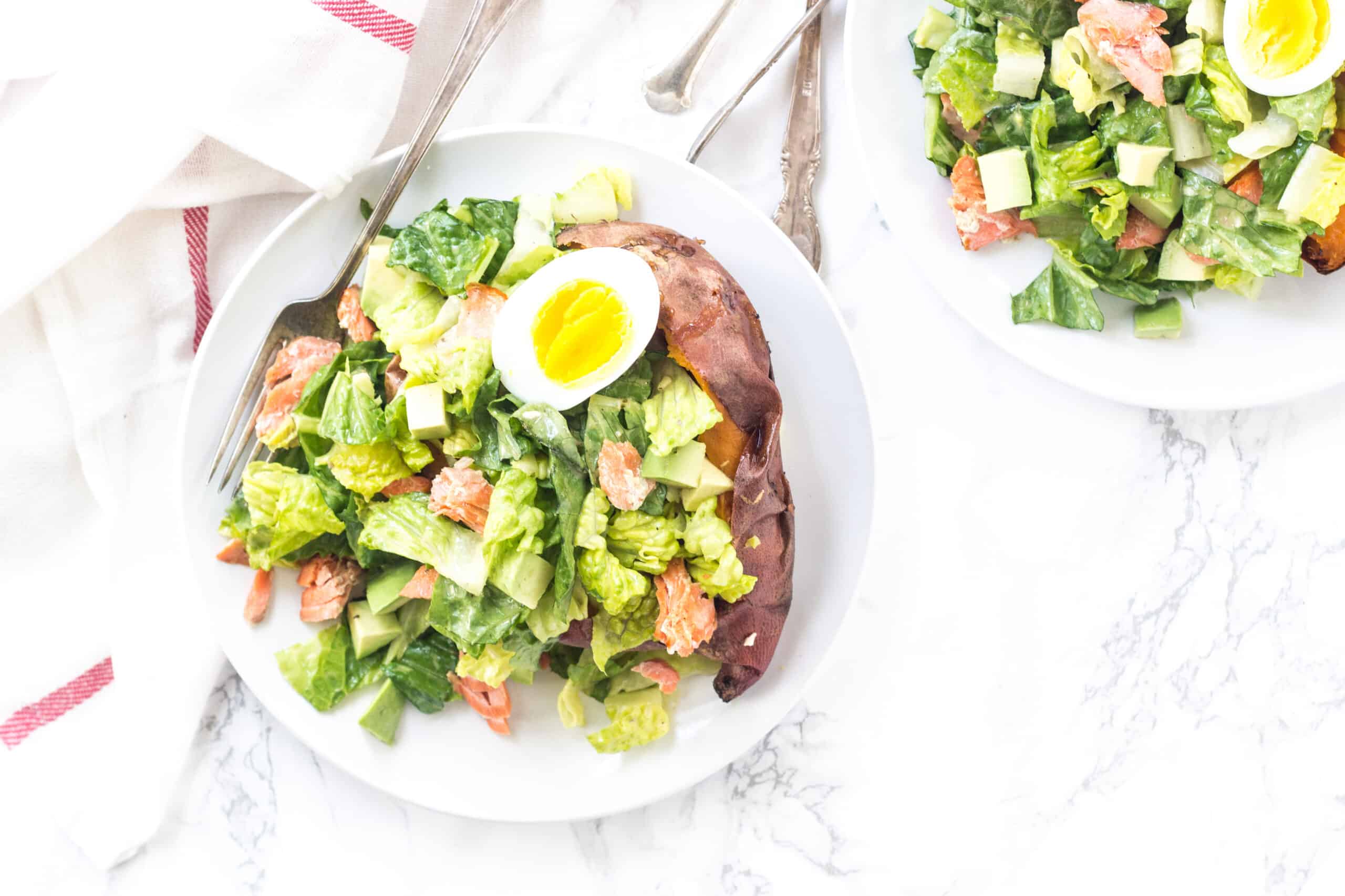 Stuffed sweet potato with caesar salad, homemade dressing, and salmon.