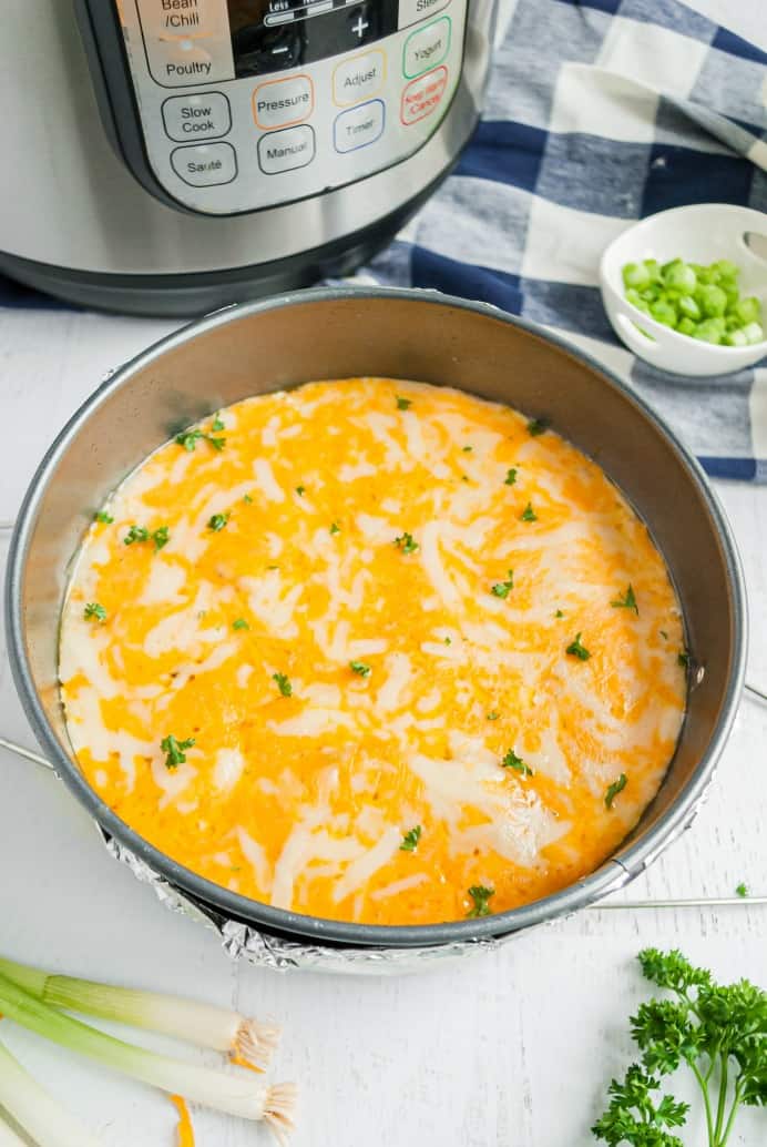 Cooked potatoes in a baking dish with melted cheese and parsley.