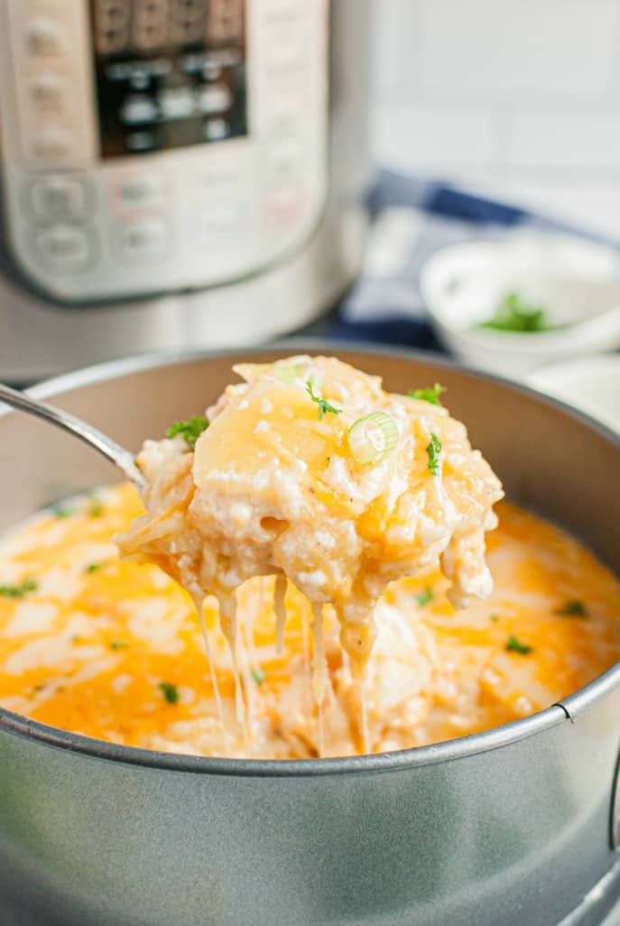 Spoonful of au gratin potatoes being lifted out of the baking dish.