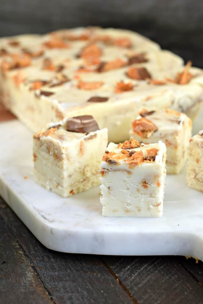 Small bites of vanilla fudge filled with pieces of butterfinger candy bars.
