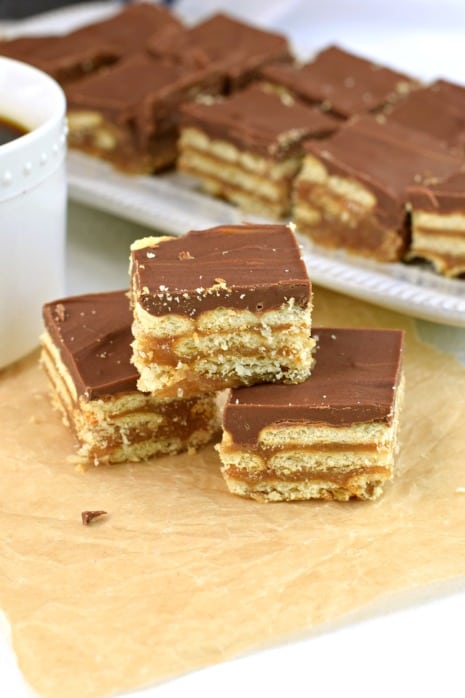 Layers of club crackers, caramel, and chocolate to create a pile of cracker bars.
