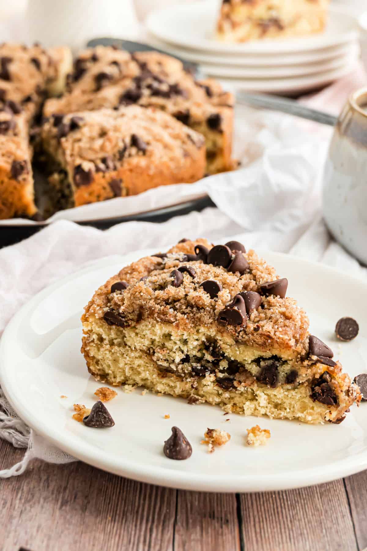 Slice of chocolate chip coffee cake on a white serving plate.