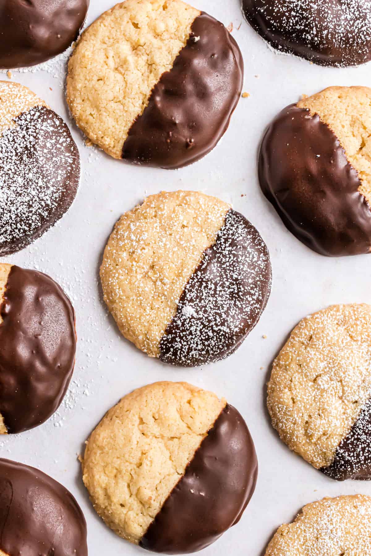 Chocolate dipped potato chip cookies on parchment paper.