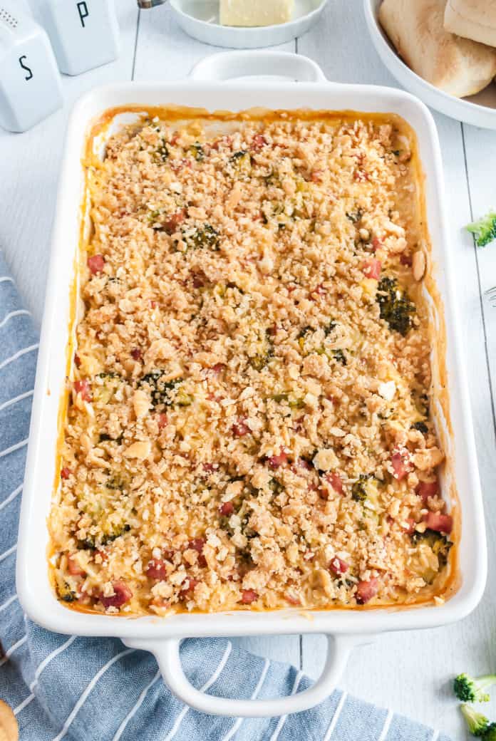 White rectangle baking dish with ham casserole topped with buttery ritz crackers.