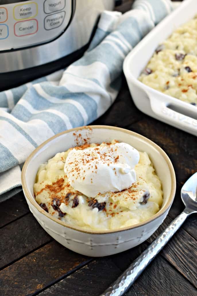 Bowl of rice pudding topped with whipped cream and cinnamon.