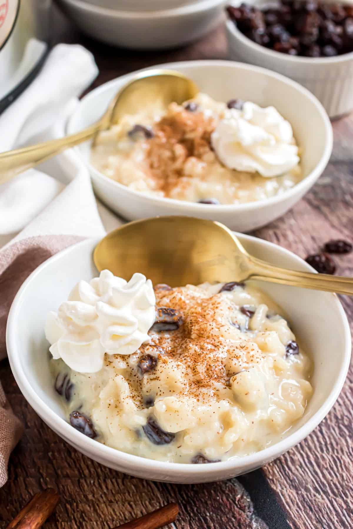 Rice pudding served with whipped cream in white bowls.