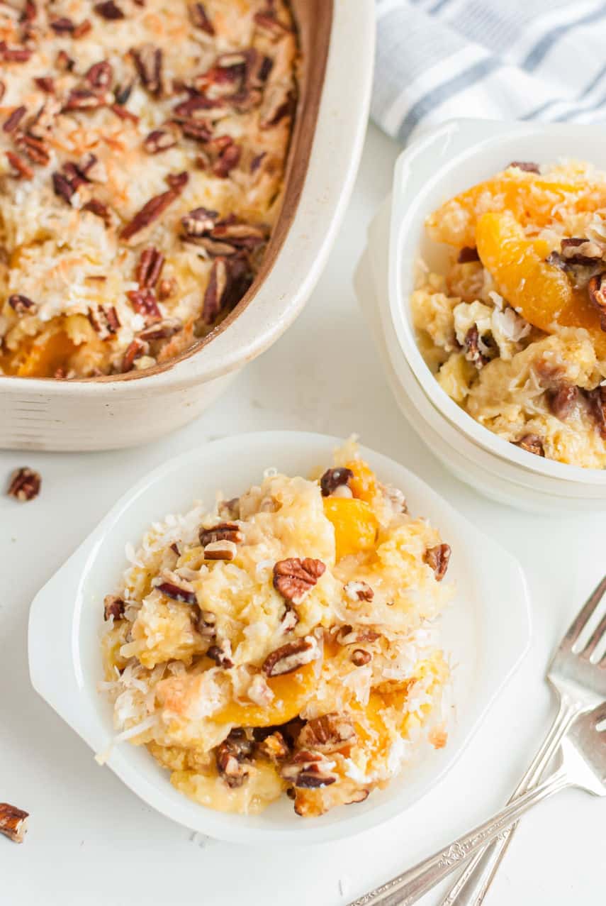 Milk glass dish with big spoonful of peach dump cake.