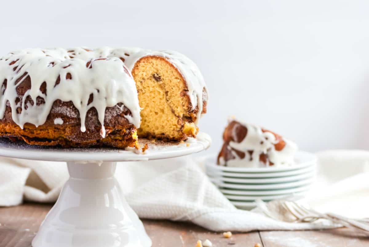 Bundt cake with vanilla glaze on a white cake platter.