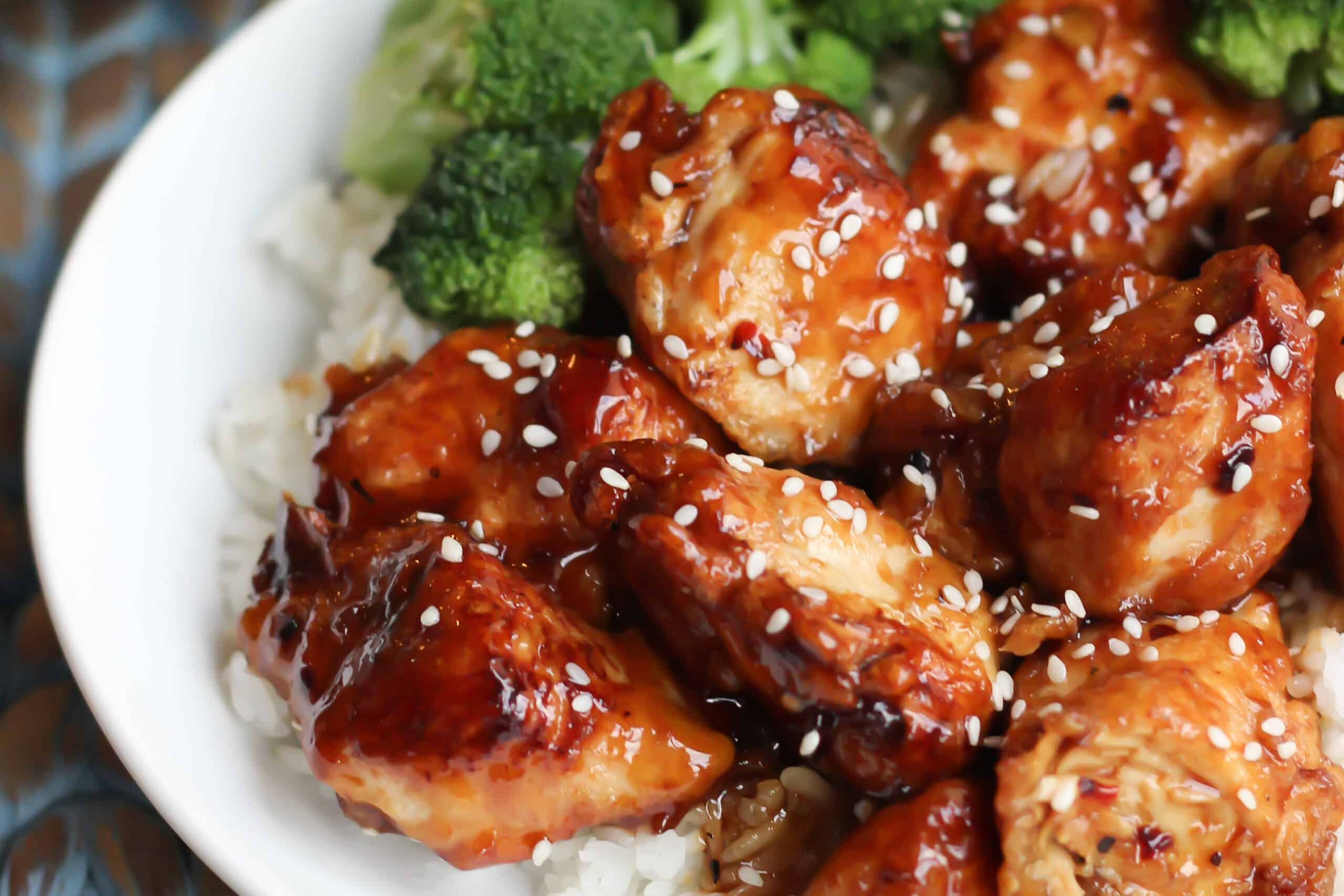 Glazed asian chicken with sesame seeds on a bed of rice and steamed broccoli.