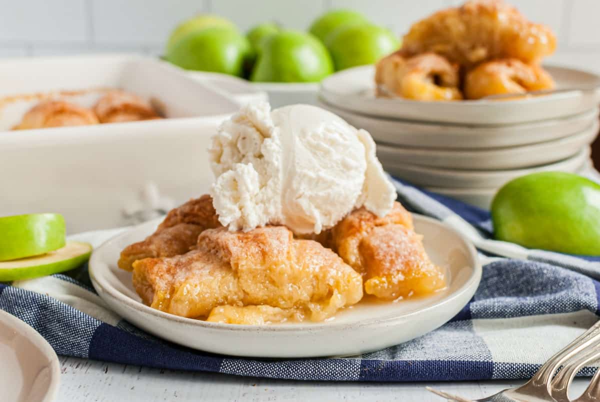 Dessert plate with apple dumplings and ice cream and granny smith apples in background.
