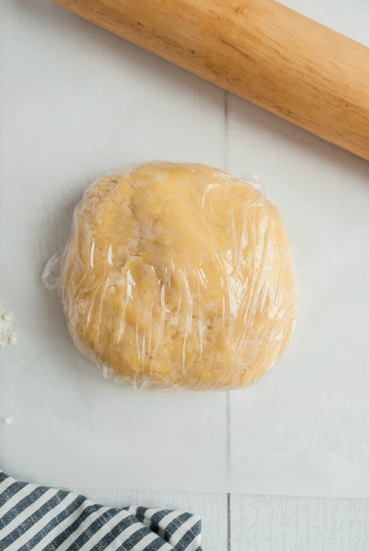 Pie crust dough wrapped in plastic wrap.