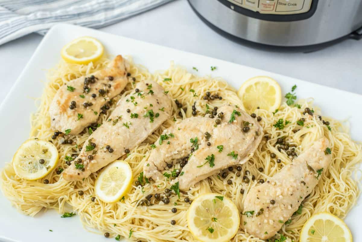 Chicken piccata served on pasta.