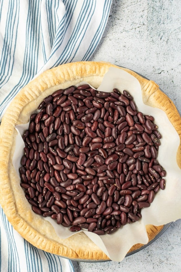 Blind baking a pie crust filled with beans.