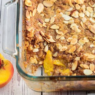 Delicious homemade Peach Crisp topped with Vanilla Ice Cream. Fresh sweet peaches with the crumbly topping make this mouthwatering dessert absolutely perfect.