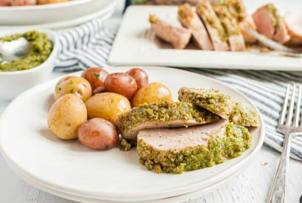 Dinner plate with pork tenderloin, pesto, and baby potatoes.