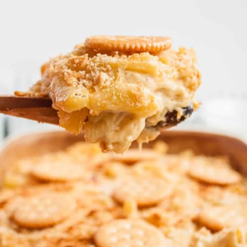 Mac and cheese with ritz topping being lifted out of pan.