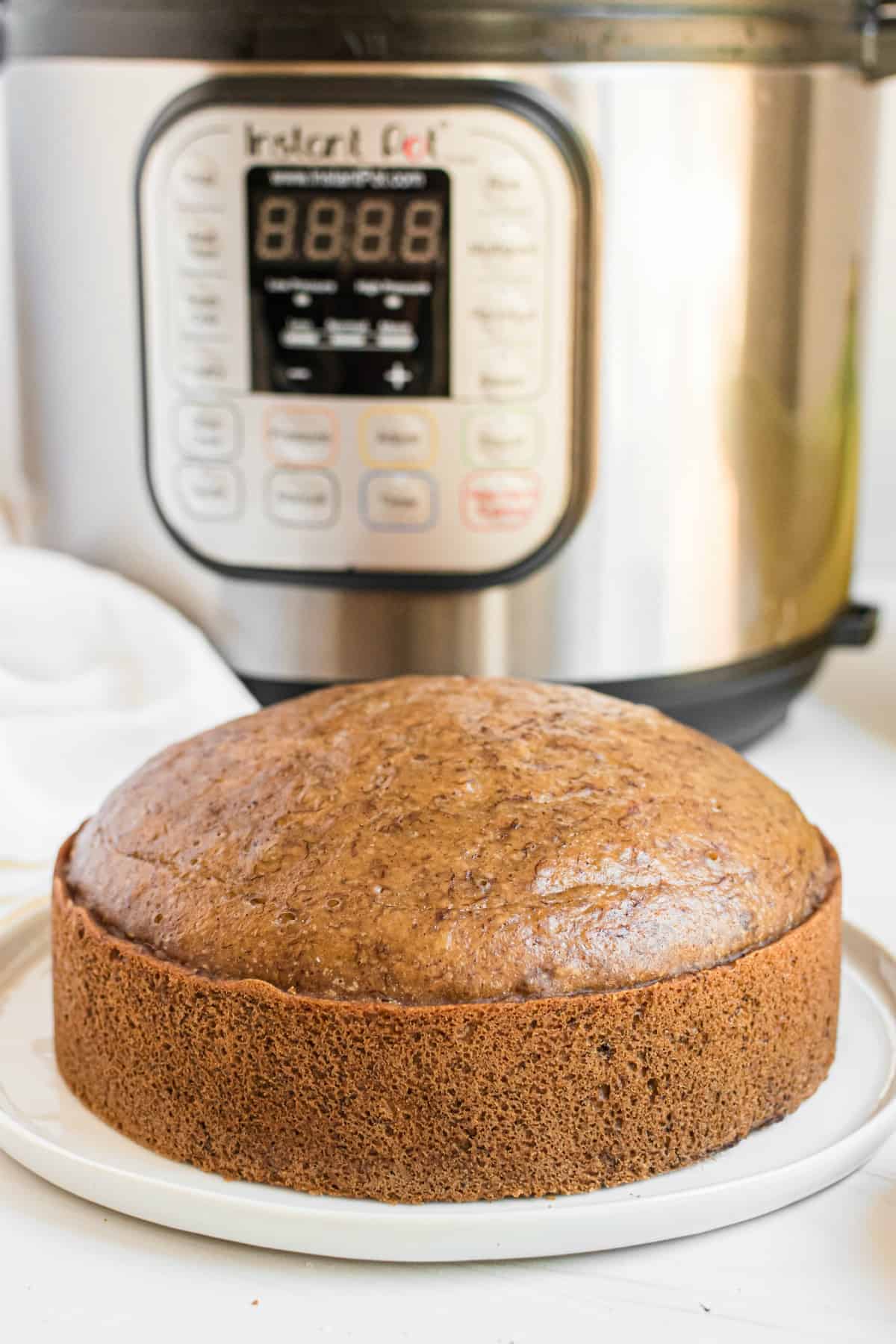 Banana Bread on a white plate with instant pot in background.