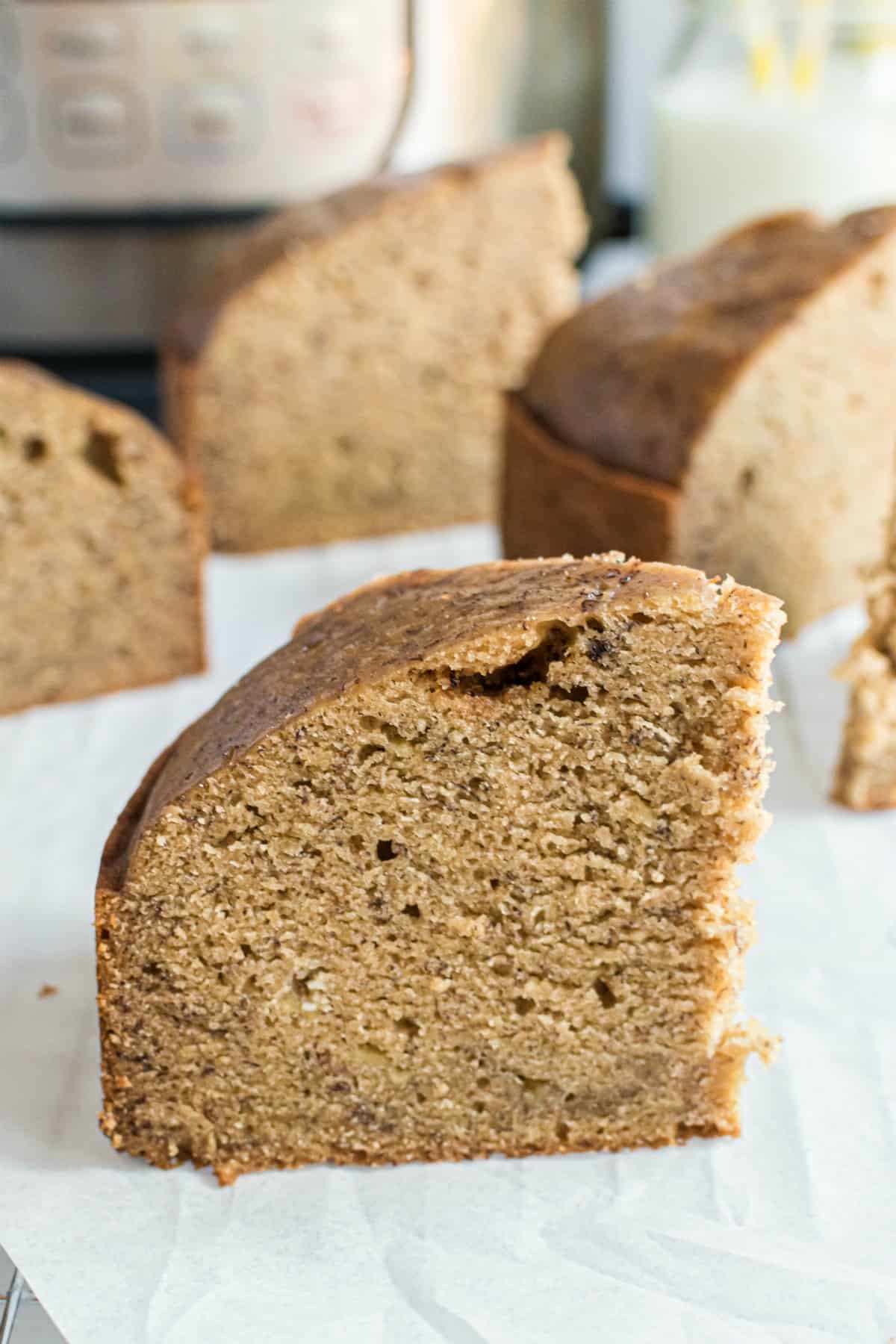 Big slice of banana bread on white plate with instapot in background.