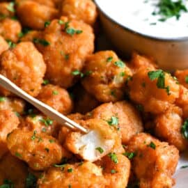 Pan fried buffalo cauliflower in a bowl with homemade ranch dressing.