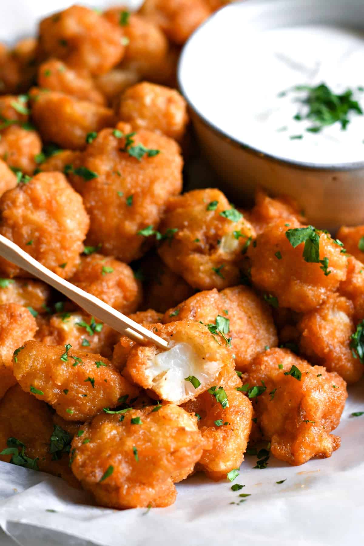 Pan fried buffalo cauliflower in a bowl with homemade ranch dressing.