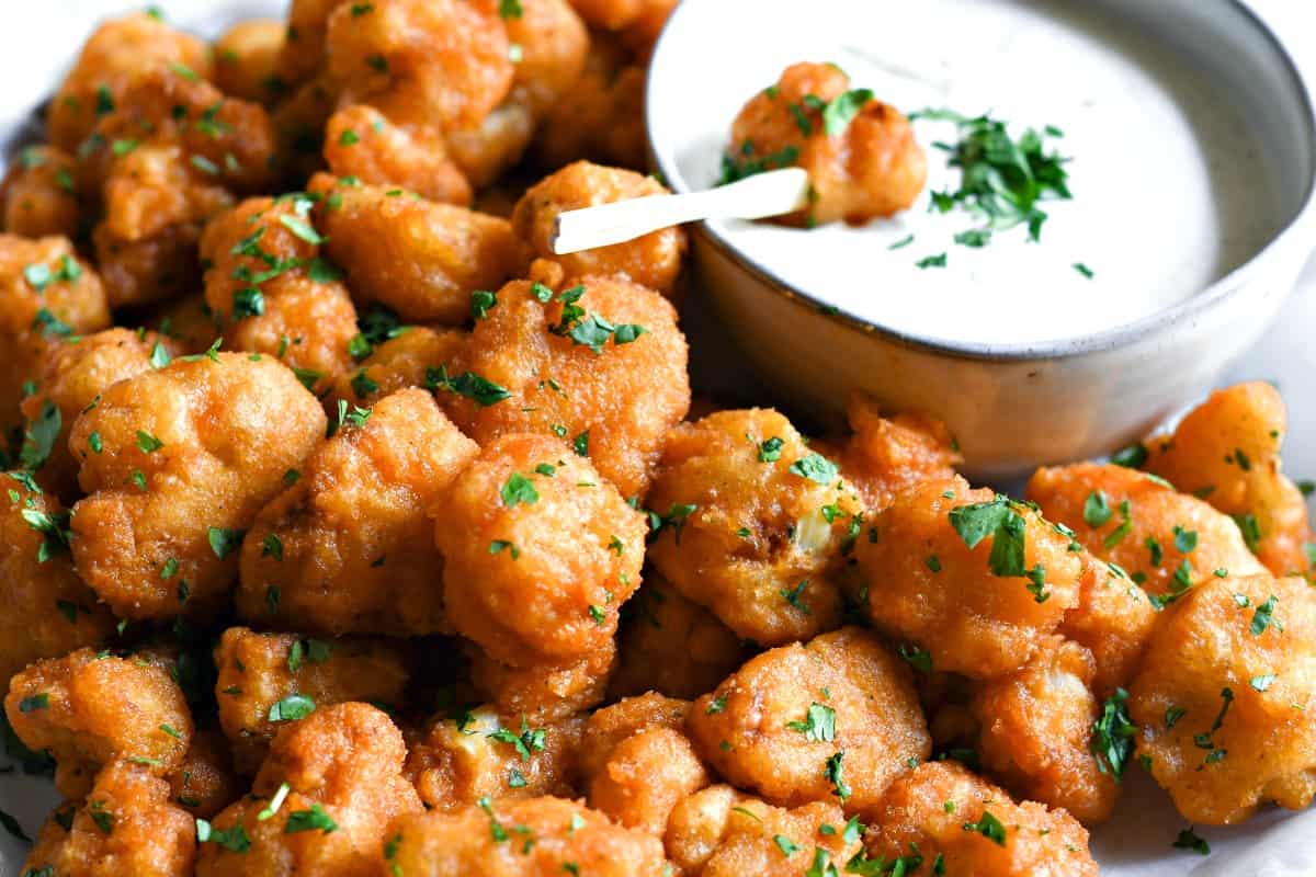Cauliflower buffalo wings in a bowl. A dish of homemade ranch on the side.