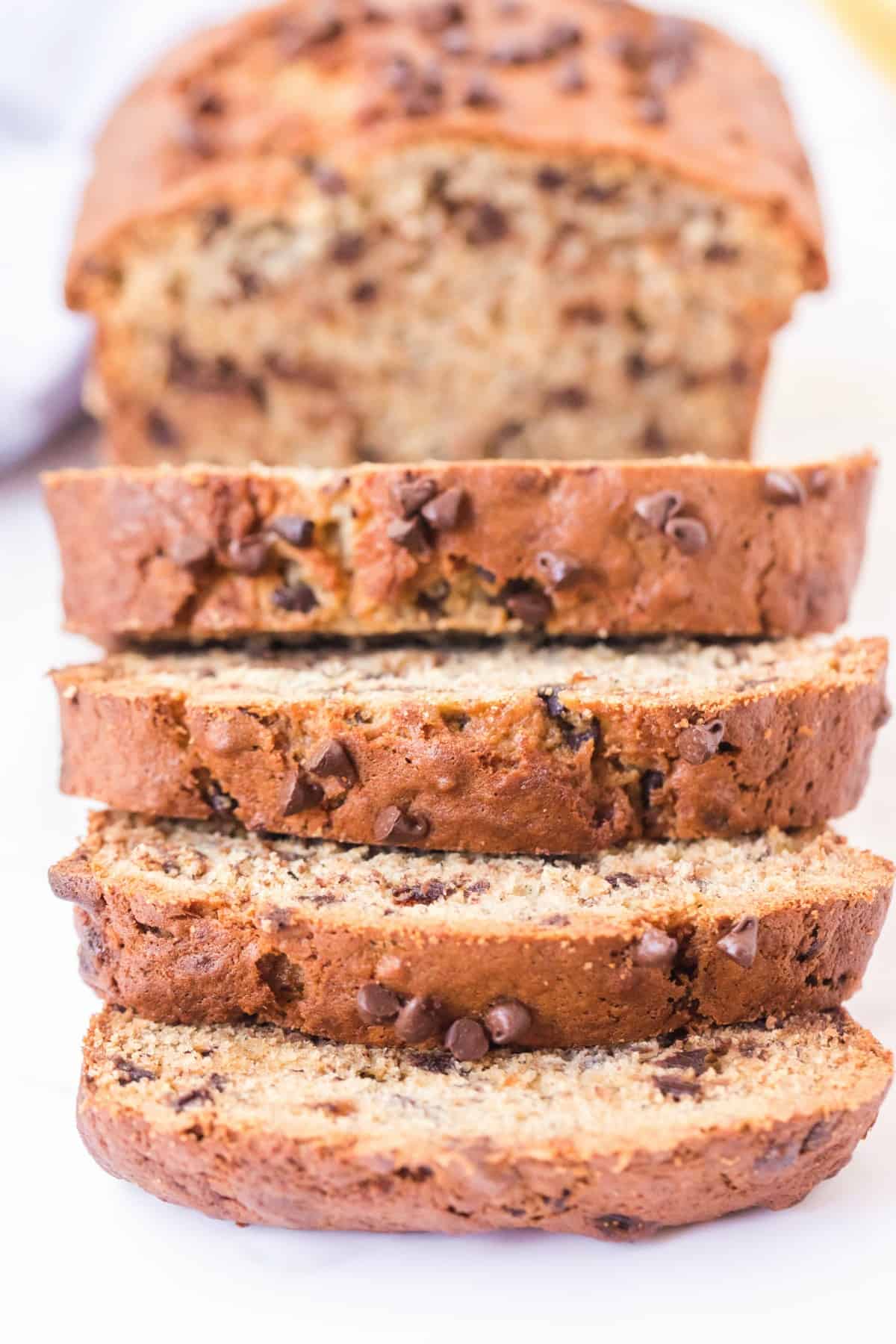 Loaf of chocolate chip banana bread with slices falling over.