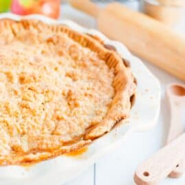 Dutch Apple Pie with streusel topping in a white pie plate.