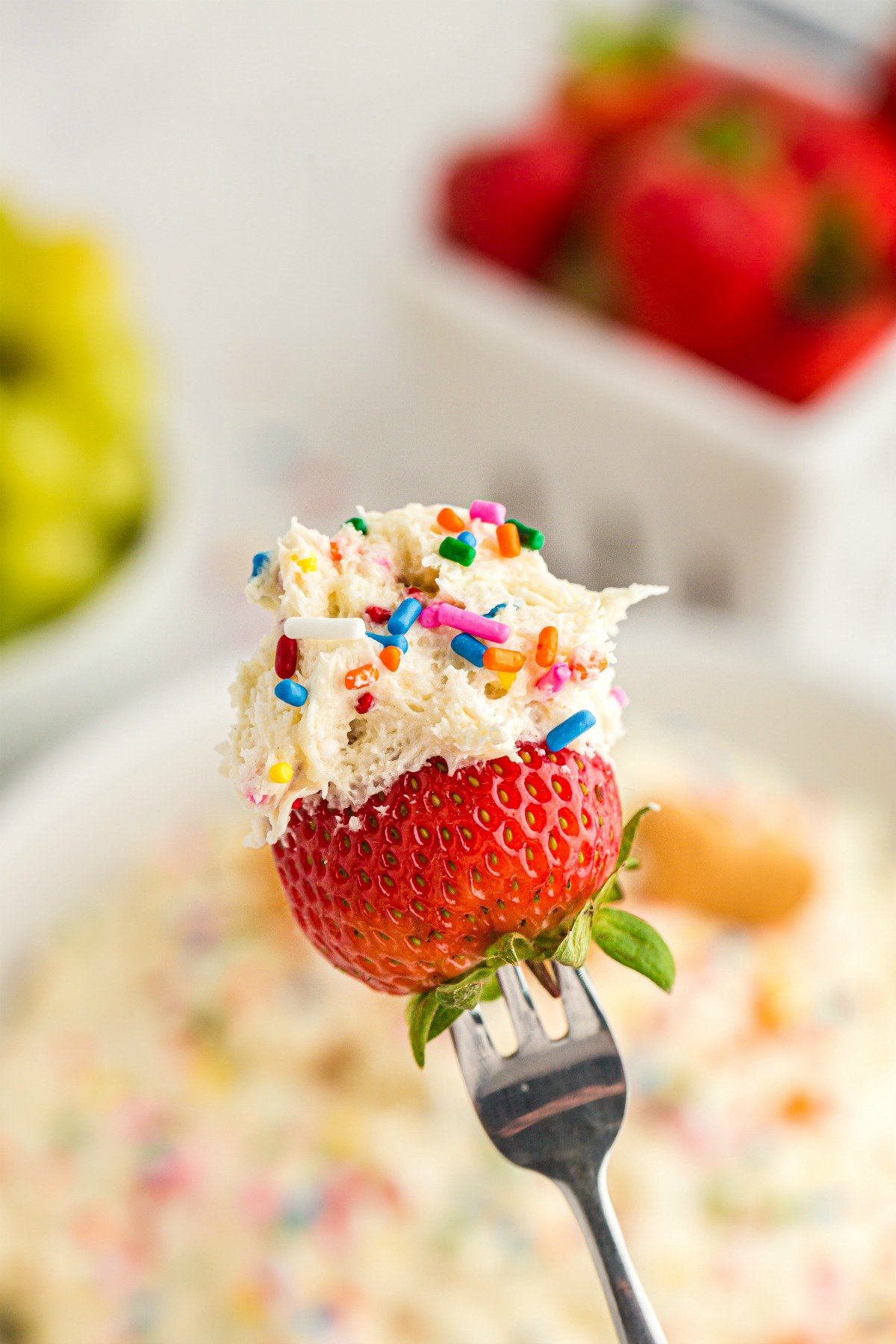 Strawberry dipped in funfetti dip with sprinkles.