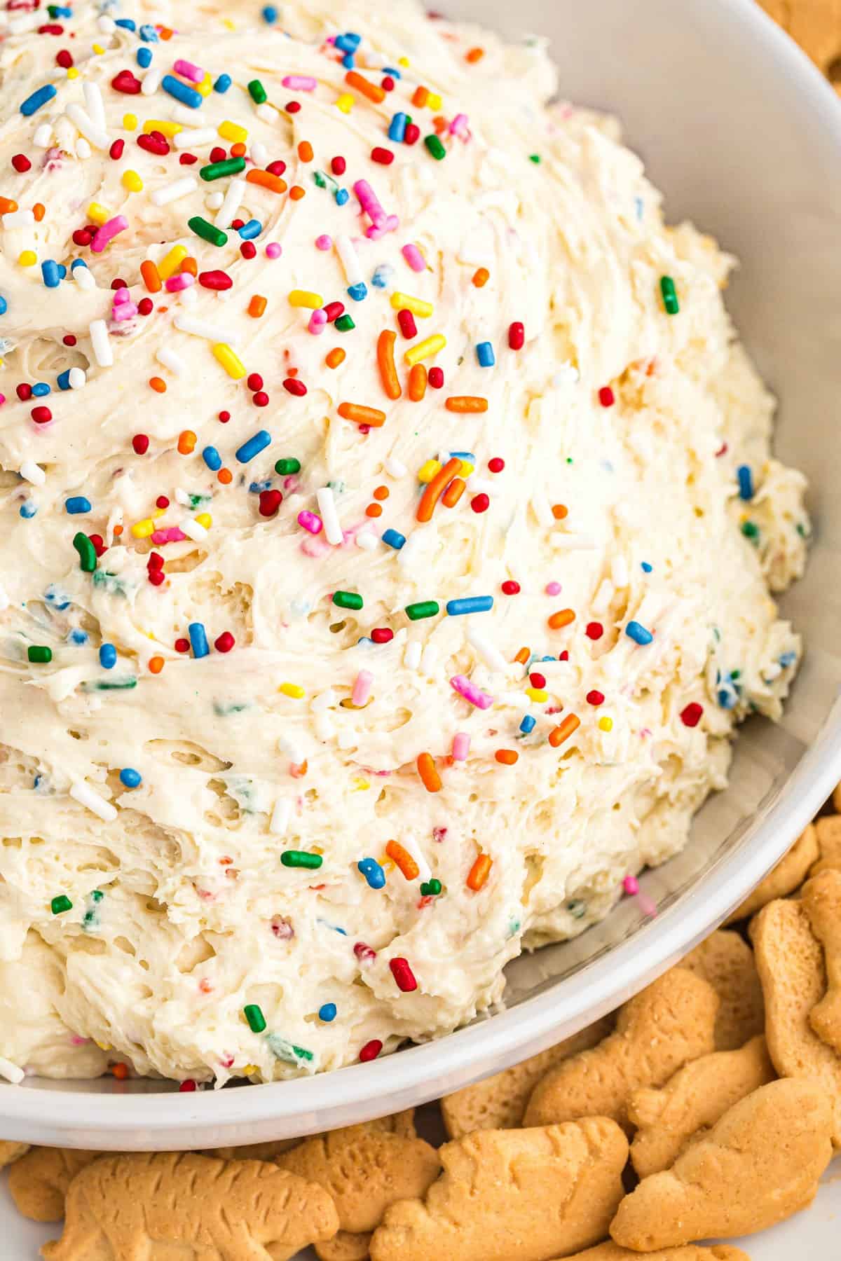 Funfetti cake batter dip in a white bowl served with animal crackers.