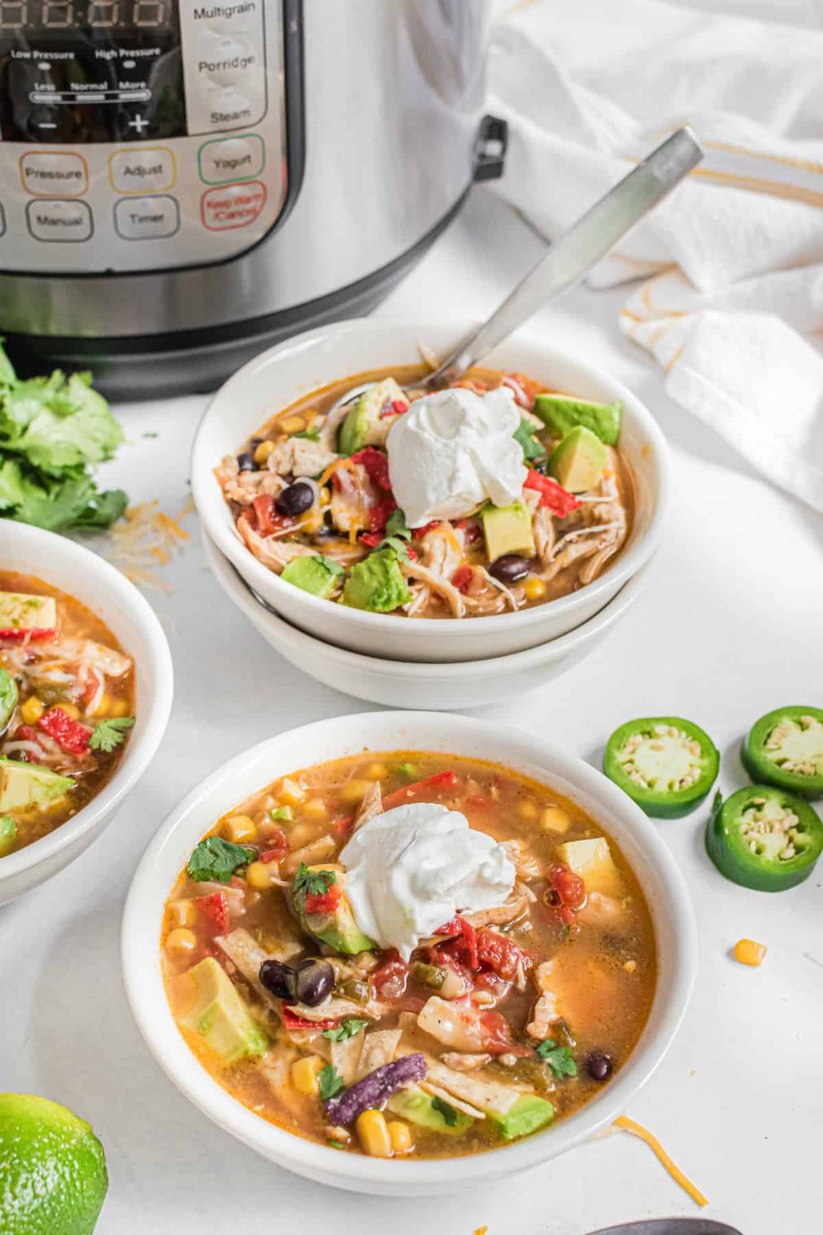 Chicken tortilla soup with pressure cooker in background.