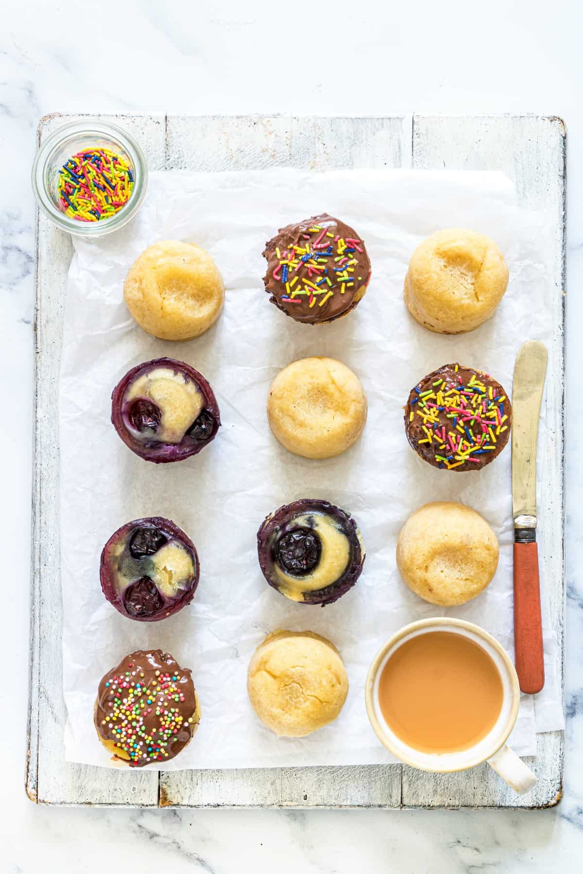Pancake bites on a white piece of parchment paper with various topping ideas.