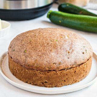 Loaf of zucchini bread on a white plate.