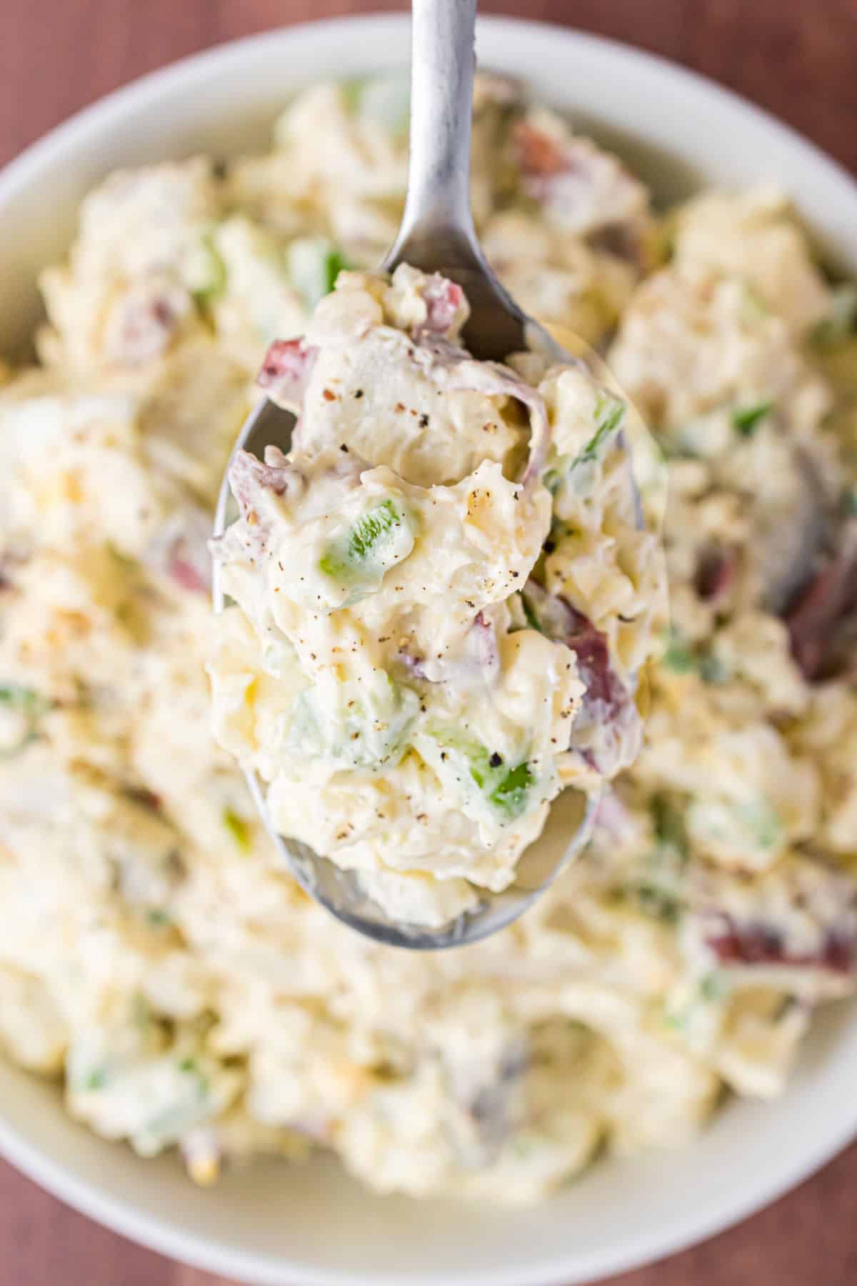 Recette de salade de pommes de terre avec des morceaux de poivrons, d'oignons, d'œufs et de mayonnaise crémeuse.