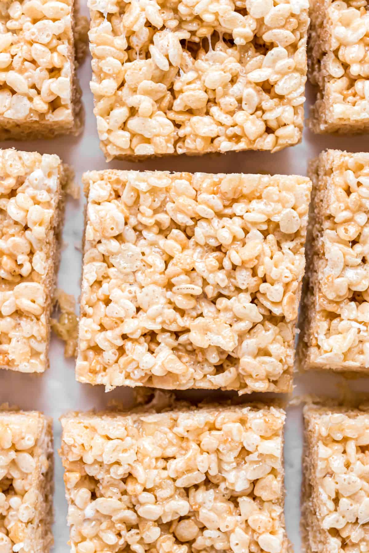 Rice crispy treats on parchment paper cut into squares or bars.