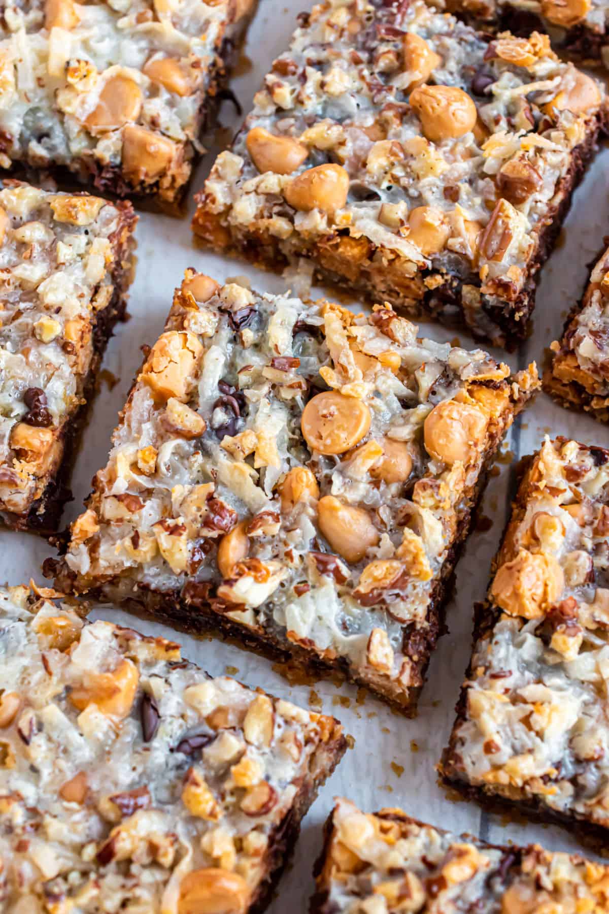 Gooey 7 layer bars on a parchment paper lined cookie sheet.