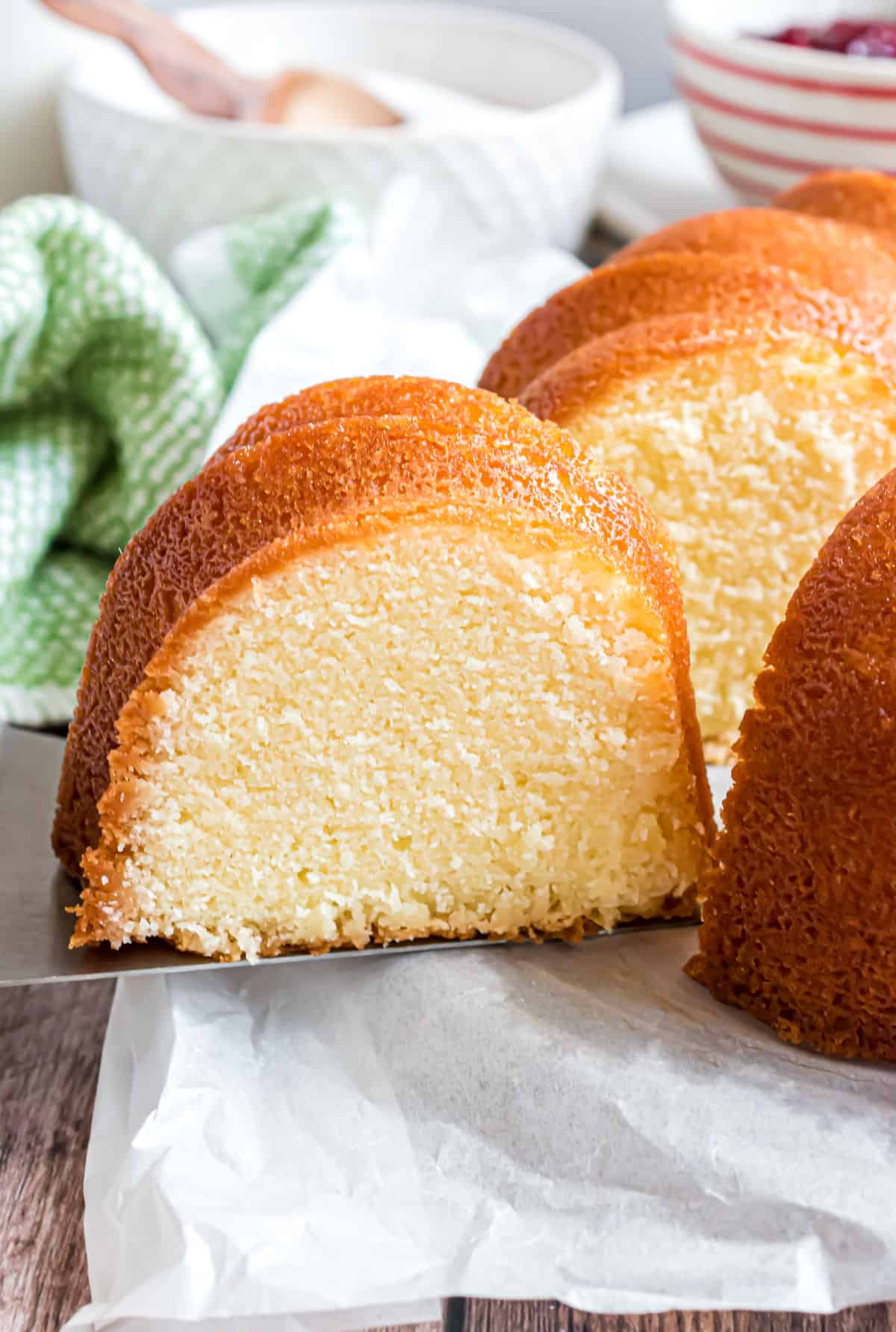 Slice of pound cake being taken off cake platter.