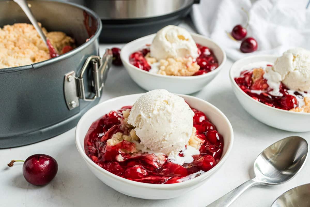 Cherry cobbler with vanilla ice cream in a bowl.