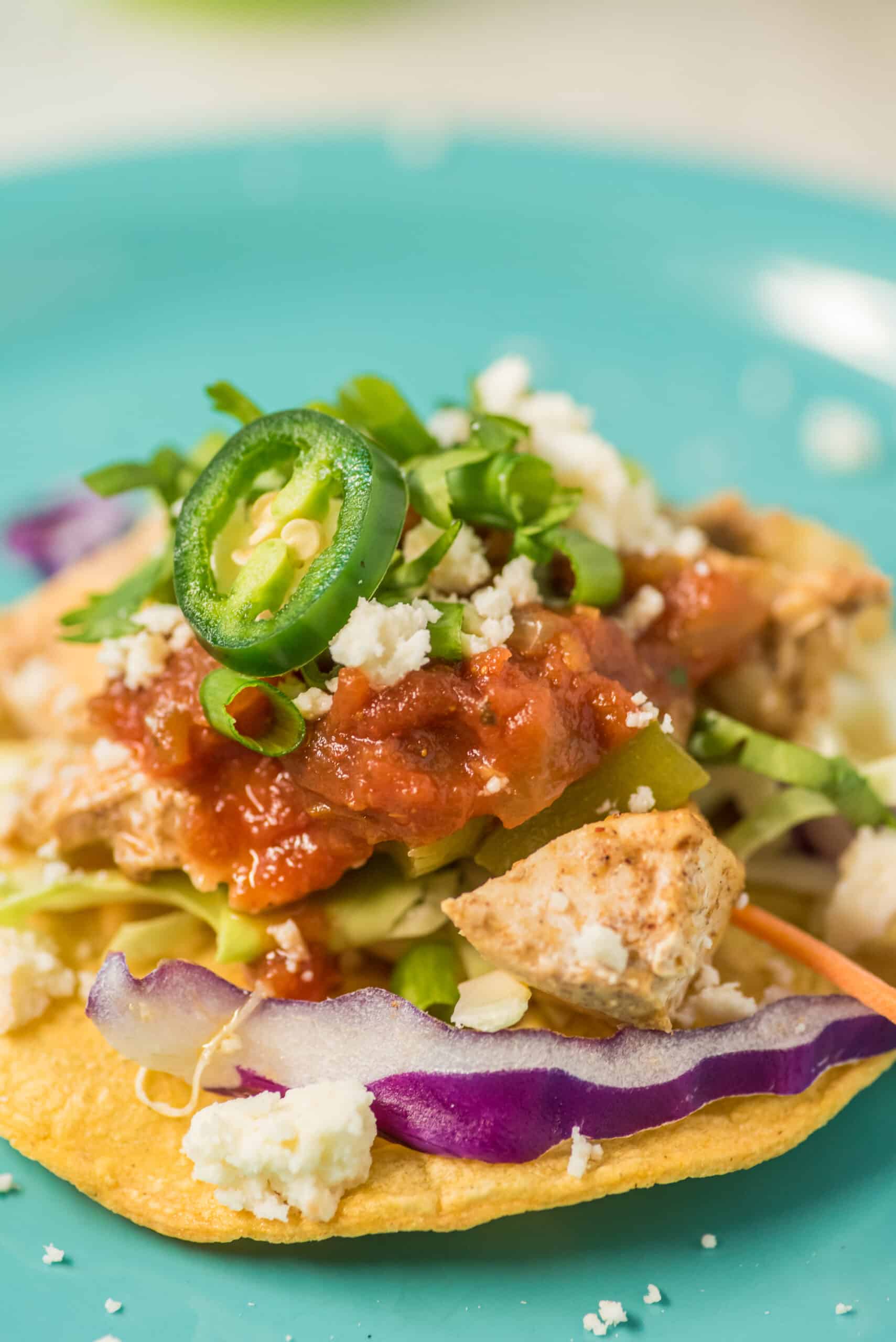 Tostada with chicken, salsa, cheese, jalapeno, and lettuce.