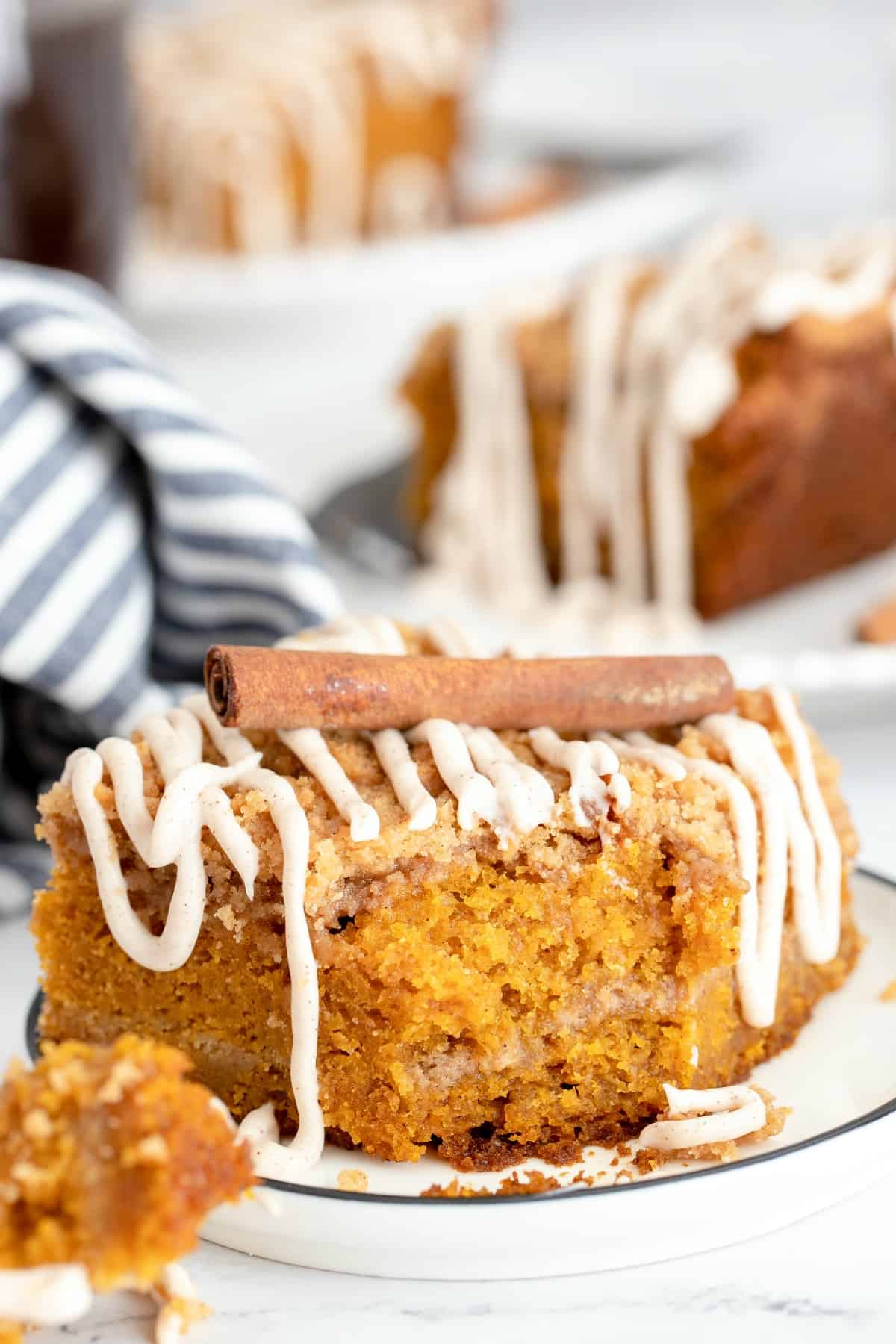 Pumpkin crumb cake with bite removed. Topped with cinnamon stick.